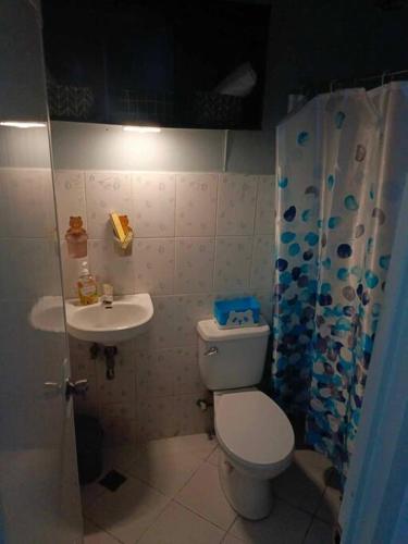 a small bathroom with a toilet and a sink at Blima Guest house in Malolos