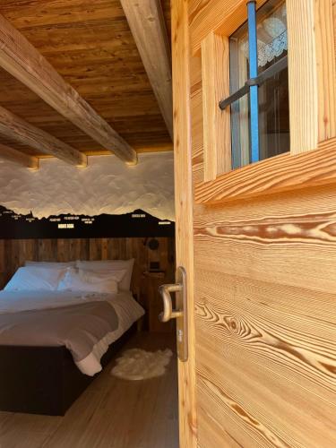 a bed in a wooden room with a window at La famille d'Evian in Villeneuve