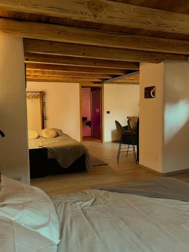 a bedroom with two beds in a room with wooden ceilings at La famille d'Evian in Villeneuve