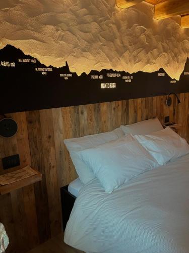 a bed with white pillows and a wall with a cloud ceiling at La famille d'Evian in Villeneuve