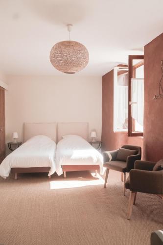 a white bedroom with a bed and a chair at Auberge Buissonniere in Gresse-en-Vercors
