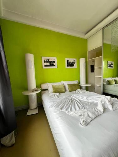 a bedroom with a large white bed in a green wall at La Renaissance hôtel Marrakech in Marrakech