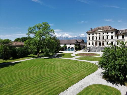 an image of a house with a green yard at Agriturismo Villa di Modolo - Cortile della Latteria in Belluno