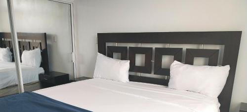 a bedroom with a large bed with white sheets and pillows at The biggest swimming pool in Sosua, frente a la piscina más grande en sosua in Sosúa