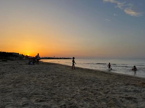 a group of people playing on the beach at sunset at B&B DA SAMUELE E ANDREA in Surbo