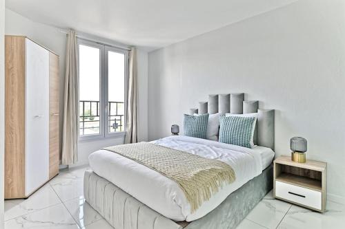 une chambre blanche avec un grand lit et une fenêtre dans l'établissement Appartement proche de Paris - Gagny - II, à Gagny