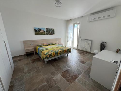 苏尔博B&B DA SAMUELE E ANDREA的一间卧室，配有一张床、一张桌子和一台冰箱