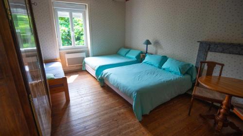 une chambre avec deux lits, une table et une fenêtre dans l'établissement Maison Cancale Port-Mer, à Cancale