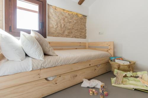 a bedroom with a wooden bed with a window at Mas d'en Jan in Roquetas