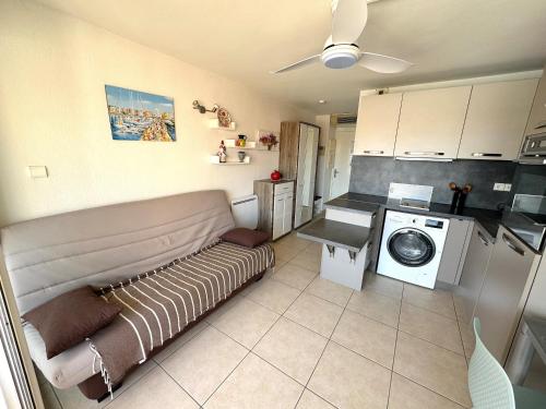 un salon avec un canapé et une machine à laver dans l'établissement Appartement Cap d'Agde vue port, au Cap d'Agde