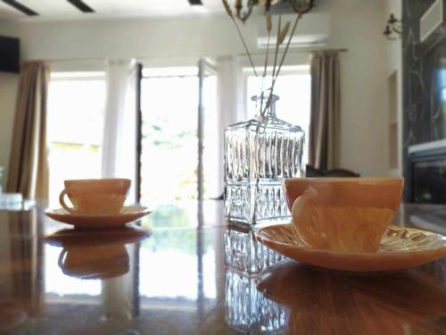 three bowls on a wooden table with a vase at Διώροφο πέτρινο σπίτι με θέα Agiasos Classic Stone House in Agiásos