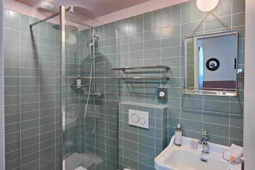 a bathroom with a shower and a sink and a mirror at Aparthotel AMMI Vieux Nice in Nice
