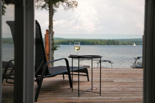 a glass of wine sitting on a table on a dock at La vie O-Lac Magog in Sherbrooke