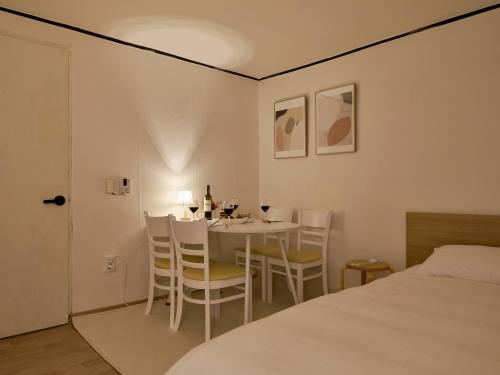 a room with a table and chairs and a bed at Warm Place in Seoul