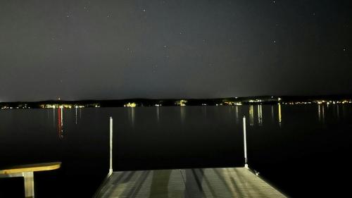 a dock in the middle of a lake at night at La vie O-Lac Magog in Sherbrooke