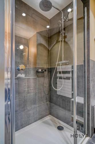 une douche avec une porte vitrée dans une salle de bain dans l'établissement Le Sublime - À Auteuil - 362B, à Paris