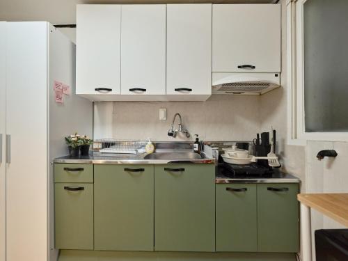 a kitchen with green cabinets and a sink at Warm Place in Seoul