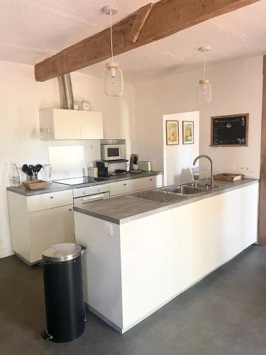 une cuisine avec des armoires blanches et un comptoir dans l'établissement domaine de montbuisson, à Tourbes