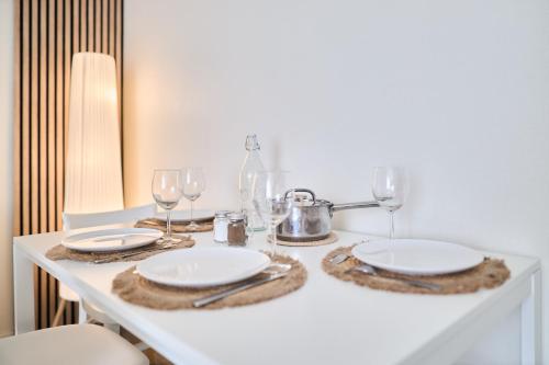 une table avec des assiettes et des verres à vin dessus dans l'établissement Le Pétillant, Gare Centre-Ville, Netflix, Wifi, à Reims