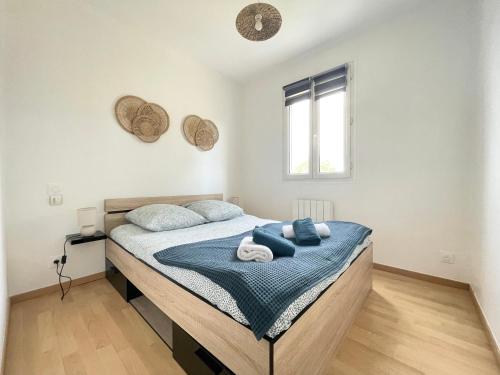 een slaapkamer met een bed met handdoeken erop bij Les chats pitres Maison au calme rénovée avec jardin, terrasse aménagée, transats, abri à vélo, parking gratuit, 5 mn à pied du centre Bayeux proche des plages du débarquement in Bayeux