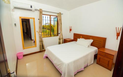 a bedroom with a white bed and a window at Orchid Villas Mauritius in Belle Mare