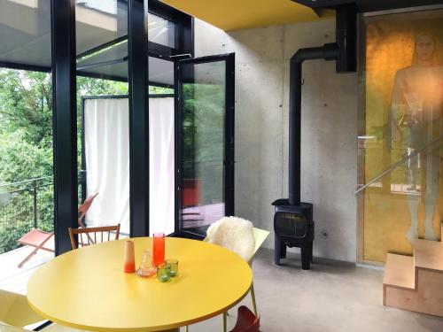 a living room with a yellow table and a stove at Ferienapartment Burgstrasse Ost mit Garten und Sauna in Altleiningen