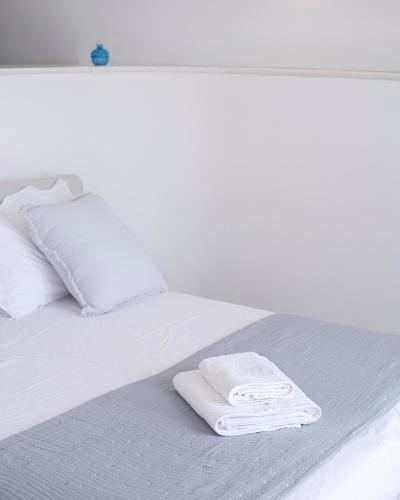 a white bed with two white towels on it at CAMPO SUITES in Kampos Paros
