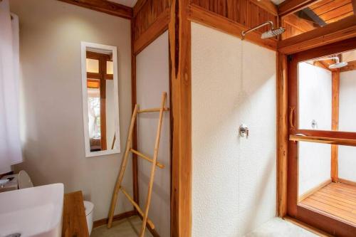 a bathroom with a toilet and a window at Aloha 15 Cottage in Ponta Mamoli