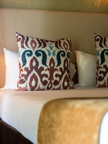 a close up of a bed with pillows at Hotel Mas Des Barres in Saintes-Maries-de-la-Mer