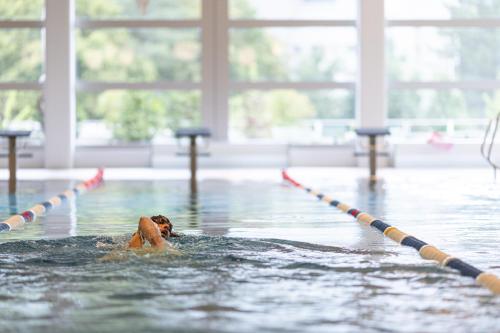 a person in a swimming pool holding onto a rope at lintharena ag in Näfels