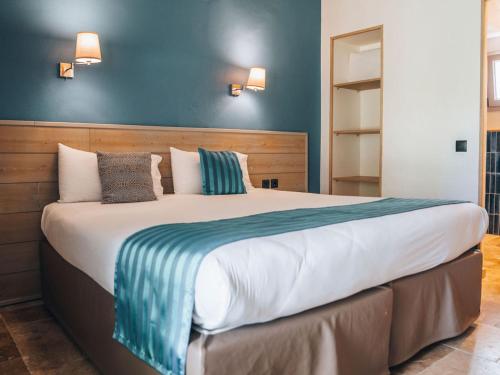 a bedroom with a large bed with blue walls at Hotel Mas Des Barres in Saintes-Maries-de-la-Mer
