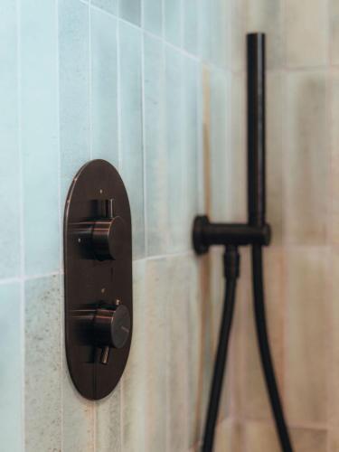 a black thermostat on the wall of a bathroom at Hotel Mas Des Barres in Saintes-Maries-de-la-Mer