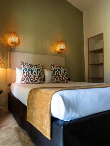 a bedroom with a large bed with pillows on it at Hotel Mas Des Barres in Saintes-Maries-de-la-Mer