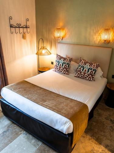 a bedroom with a large white bed with pillows at Hotel Mas Des Barres in Saintes-Maries-de-la-Mer