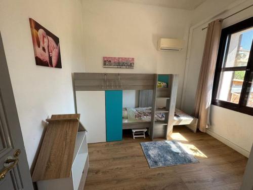 - une petite chambre avec des lits superposés et une fenêtre dans l'établissement Rez de villa avec jardin à 6 min des plages, à Cannes