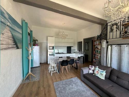 un salon avec un canapé et une cuisine dans l'établissement Rez de villa avec jardin à 6 min des plages, à Cannes