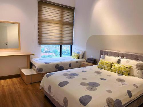 a bedroom with two beds and a mirror at Muji style The Cove Ipoh in Ipoh