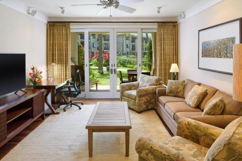 a living room with a couch and a tv at The Ritz-Carlton O'ahu, Turtle Bay in Kahuku