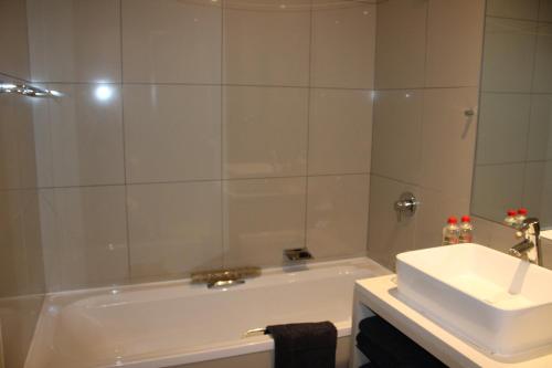 a bathroom with a white tub and a sink at The Caledon Hotel and Spa in Caledon