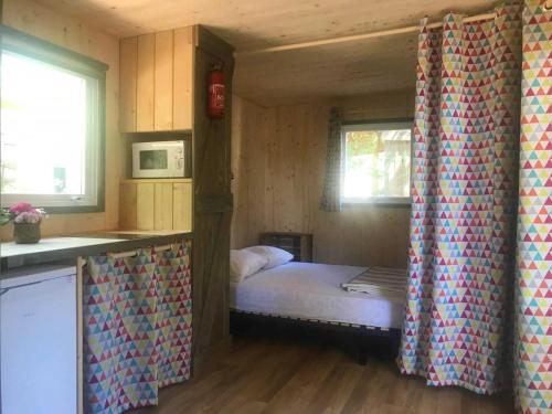Cette petite chambre comprend un lit et une cuisine. dans l'établissement Cabane 3 étoiles - cca0gbc, à Saint-Jean-Pla-de-Corts