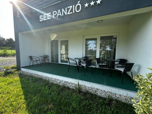a patio with tables and chairs outside of a building at See Panzió in Fertőrákos