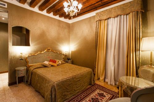 a bedroom with a bed and a chandelier at Hotel Al Ponte Mocenigo in Venice