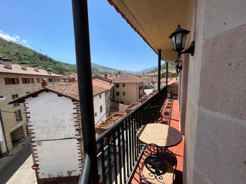 a balcony with a table and a view of a city at Alojamiento Las Endrinas in Ezcaray