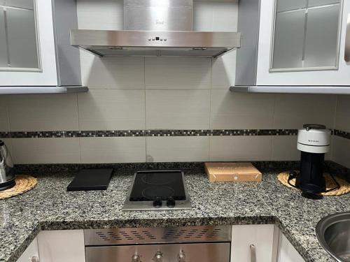 a kitchen counter with a stove and a sink at Sea City Torremolinos Beach in Torremolinos