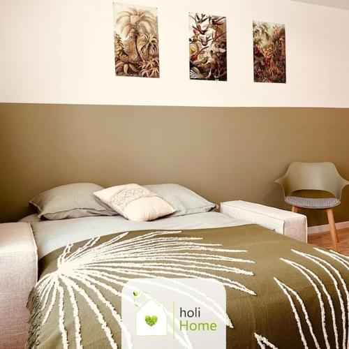 a bed in a bedroom with three pictures on the wall at H8-2 Parenthèse du Val Nançon in Fougères