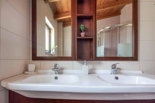 Un baño con dos lavabos y un espejo. en Villa Mandarin Platanias, en Plataniás