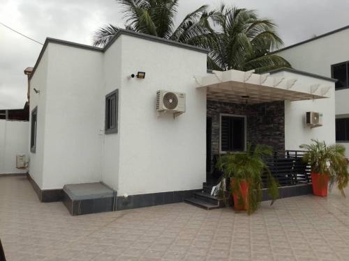 un edificio blanco con porche y palmeras en Serene 2 Bedroom House, en Ogbojo