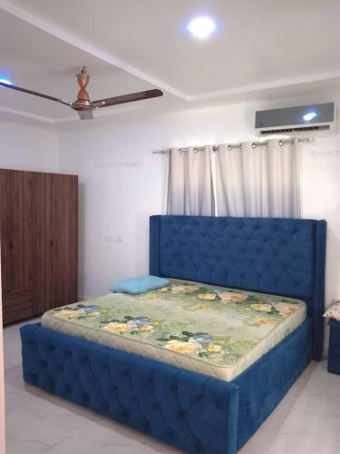 Cama en habitación con cabecera azul en Serene 2 Bedroom House, en Ogbojo