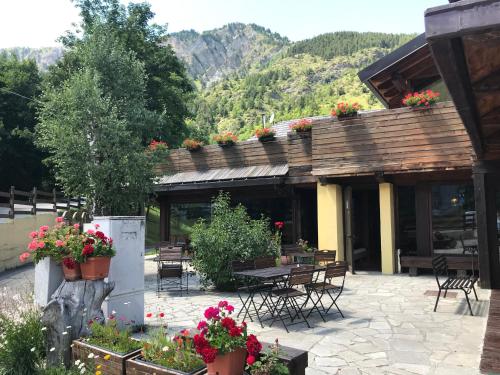 a patio with tables and chairs and flowers at Hotel Cà Fiore in Bardonecchia