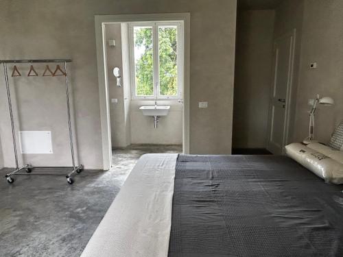 a bedroom with a bed with a sink and a window at La Torre Granaia in Serravalle Scrivia